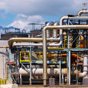 A modern industrial plant with large silver pipelines and structures, against a dusky sky, showcasing advanced energy or manufacturing infrastructure.
