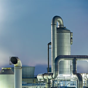 A modern industrial plant with large silver pipelines and structures, against a dusky sky, showcasing advanced energy or manufacturing infrastructure.