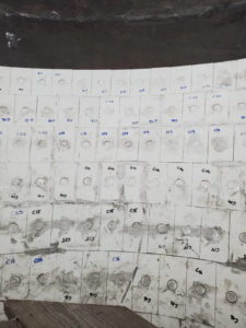 Close-up of a grid of white numbered tiles with circular cutouts, likely part of a heat-resistant industrial lining.
